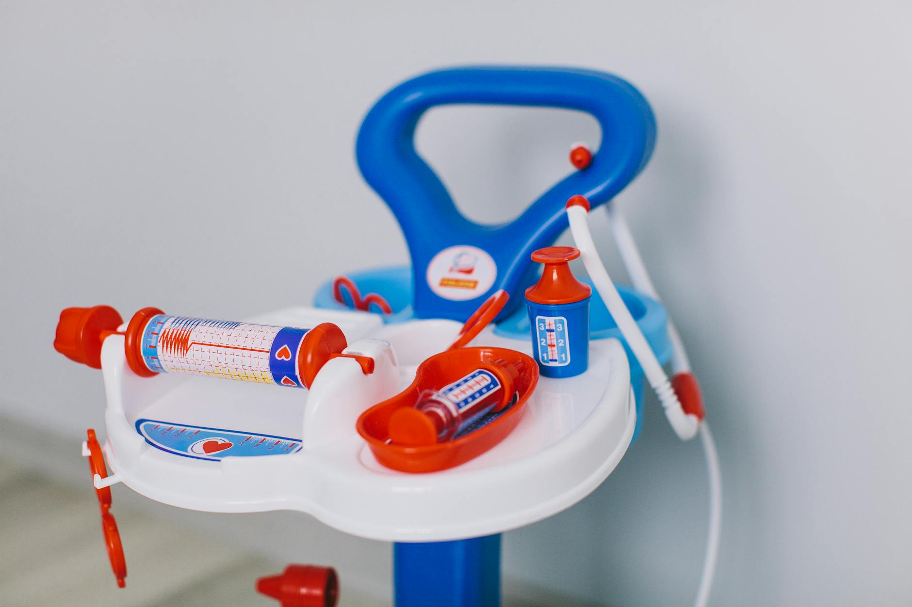 Bright toy medical set with syringes and bottles on white tray for kids' role play.