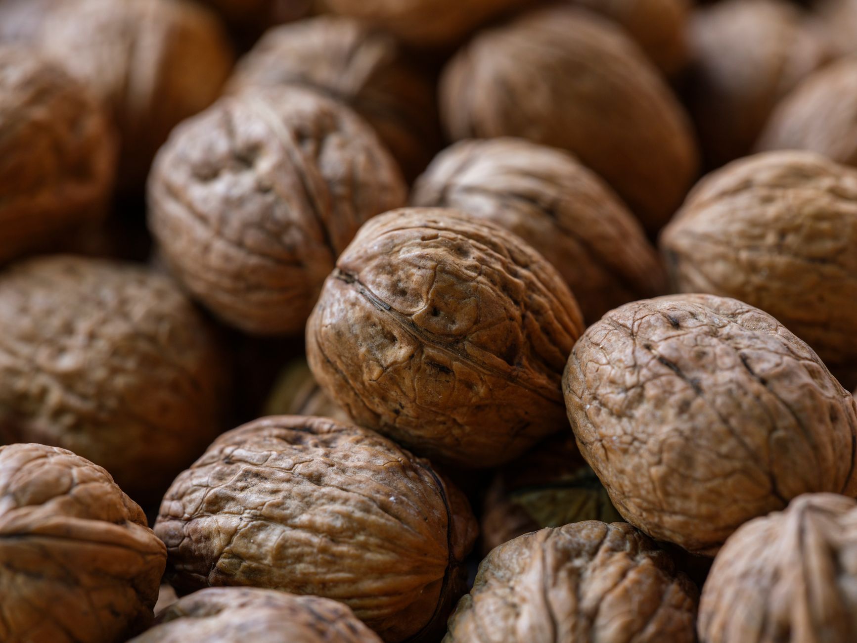 Macro shot highlighting texture of fresh organic walnuts. Ideal for health and food themes.