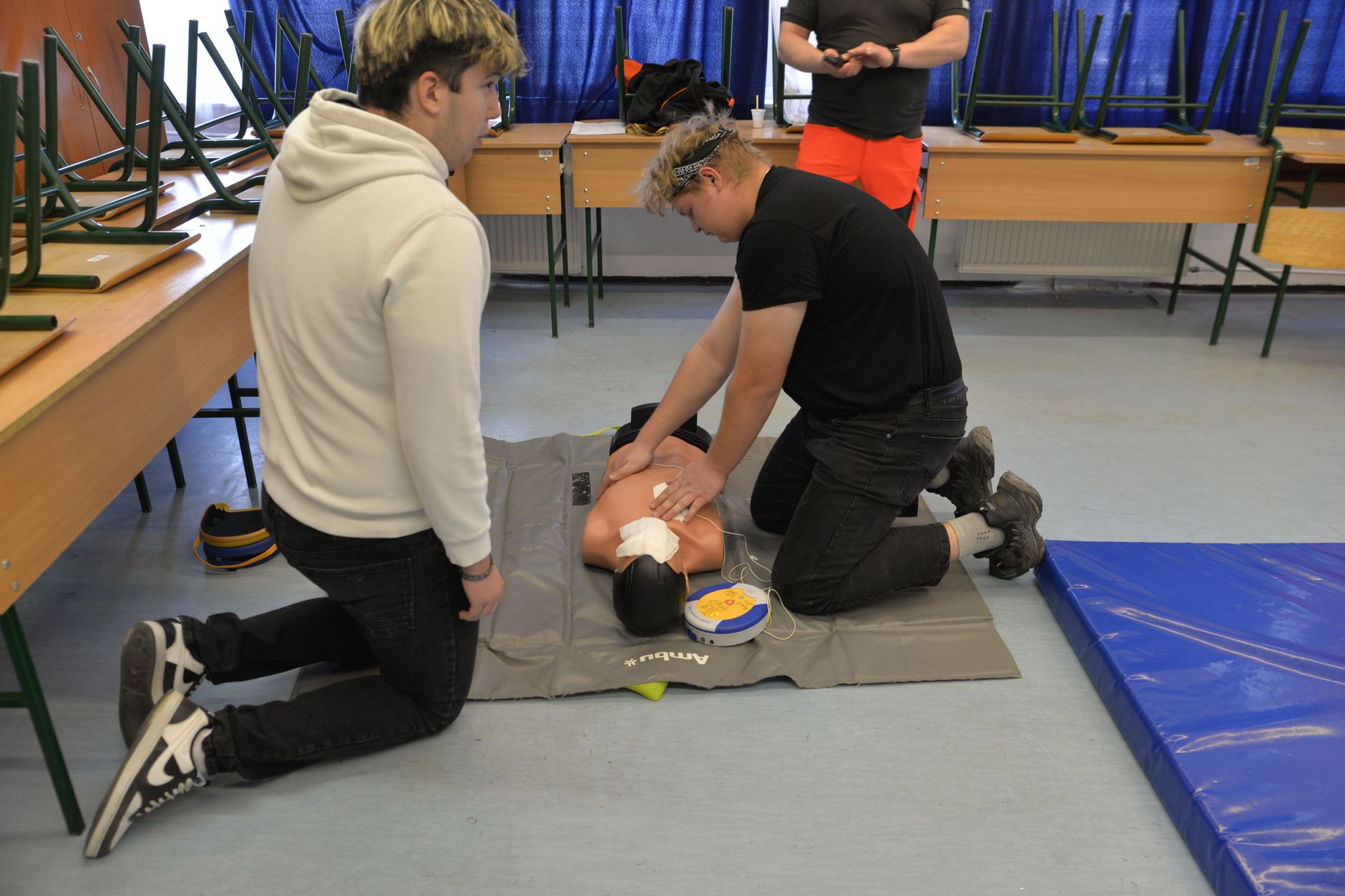 CPR training session with a dummy in a classroom environment.