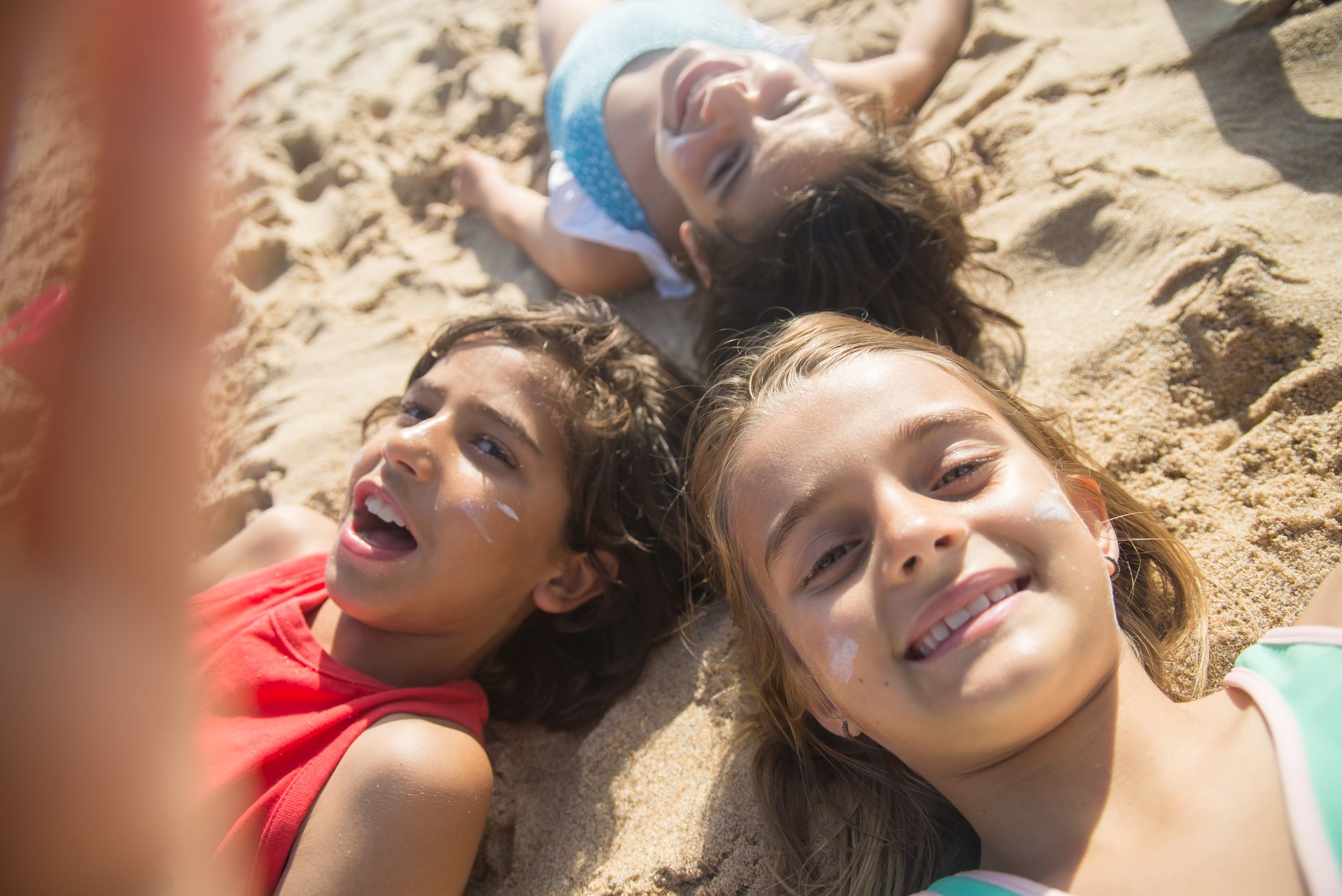 A group of joyful children having fun at the beach during summer, enjoying a sunny day together.