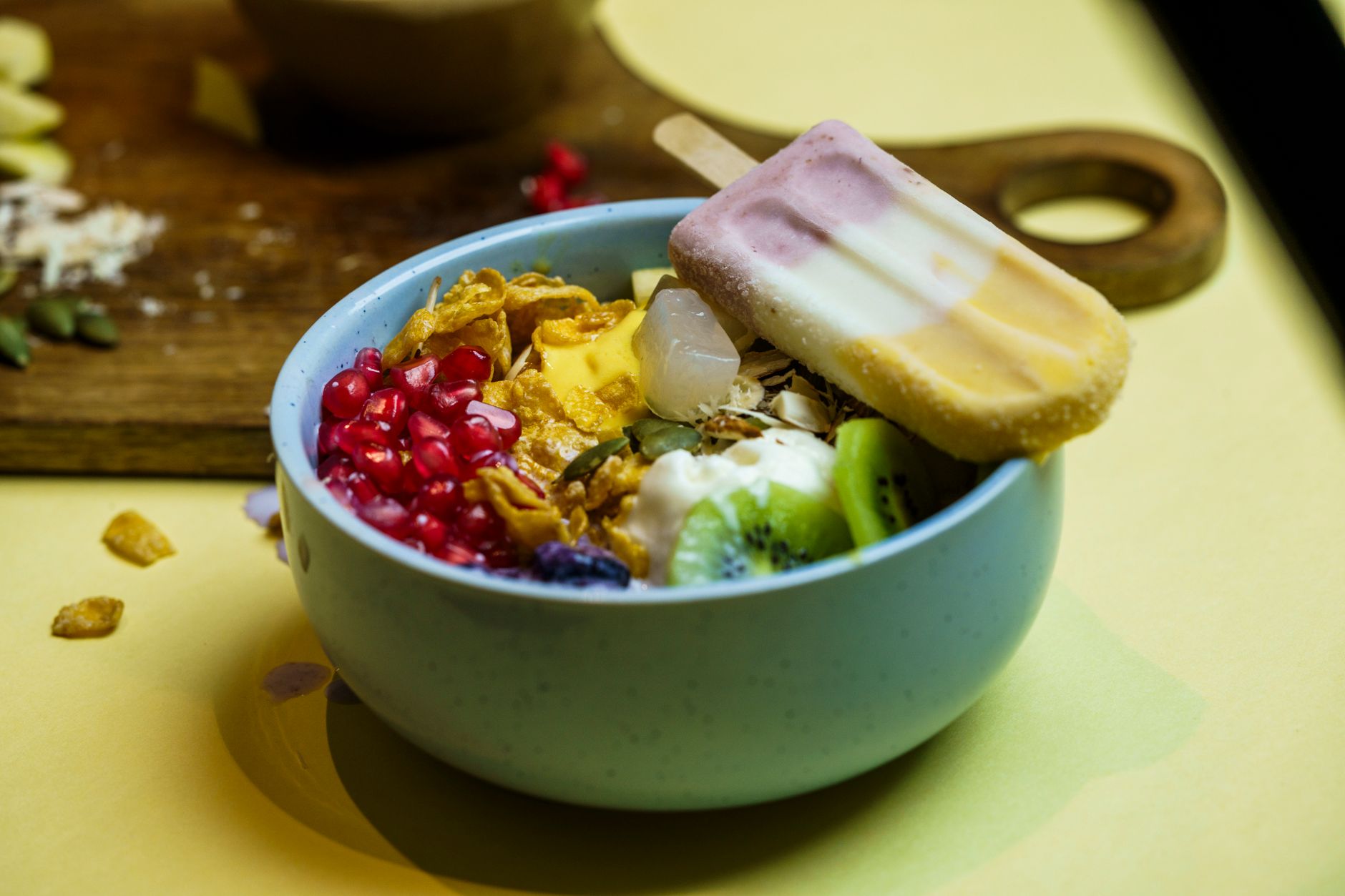 Vibrant breakfast bowl featuring fresh fruits, yogurt, and a popsicle served in a ceramic bowl.