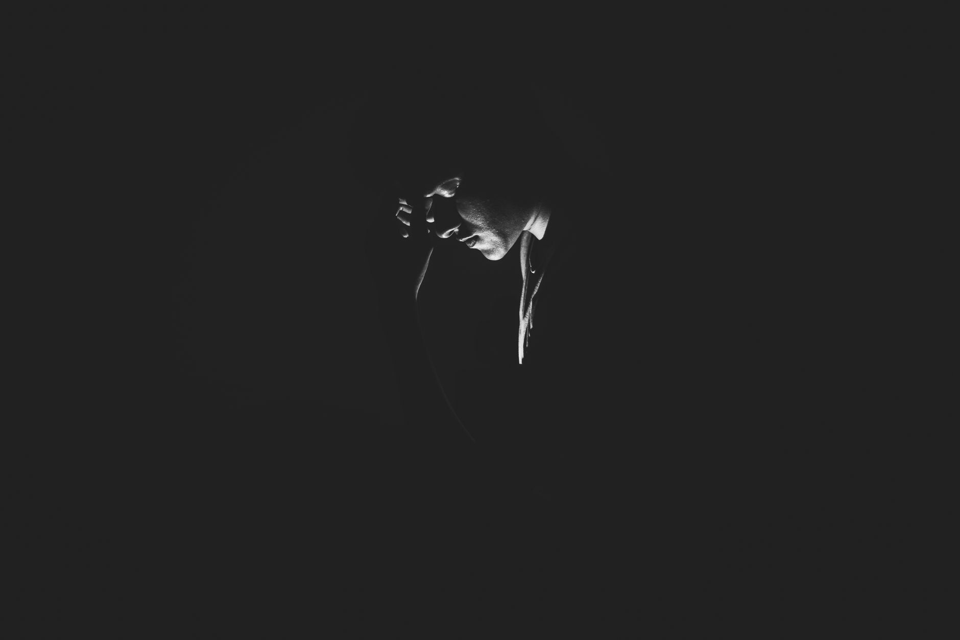 A solitary man is captured in a black and white moody setting, evoking feelings of loneliness and introspection.