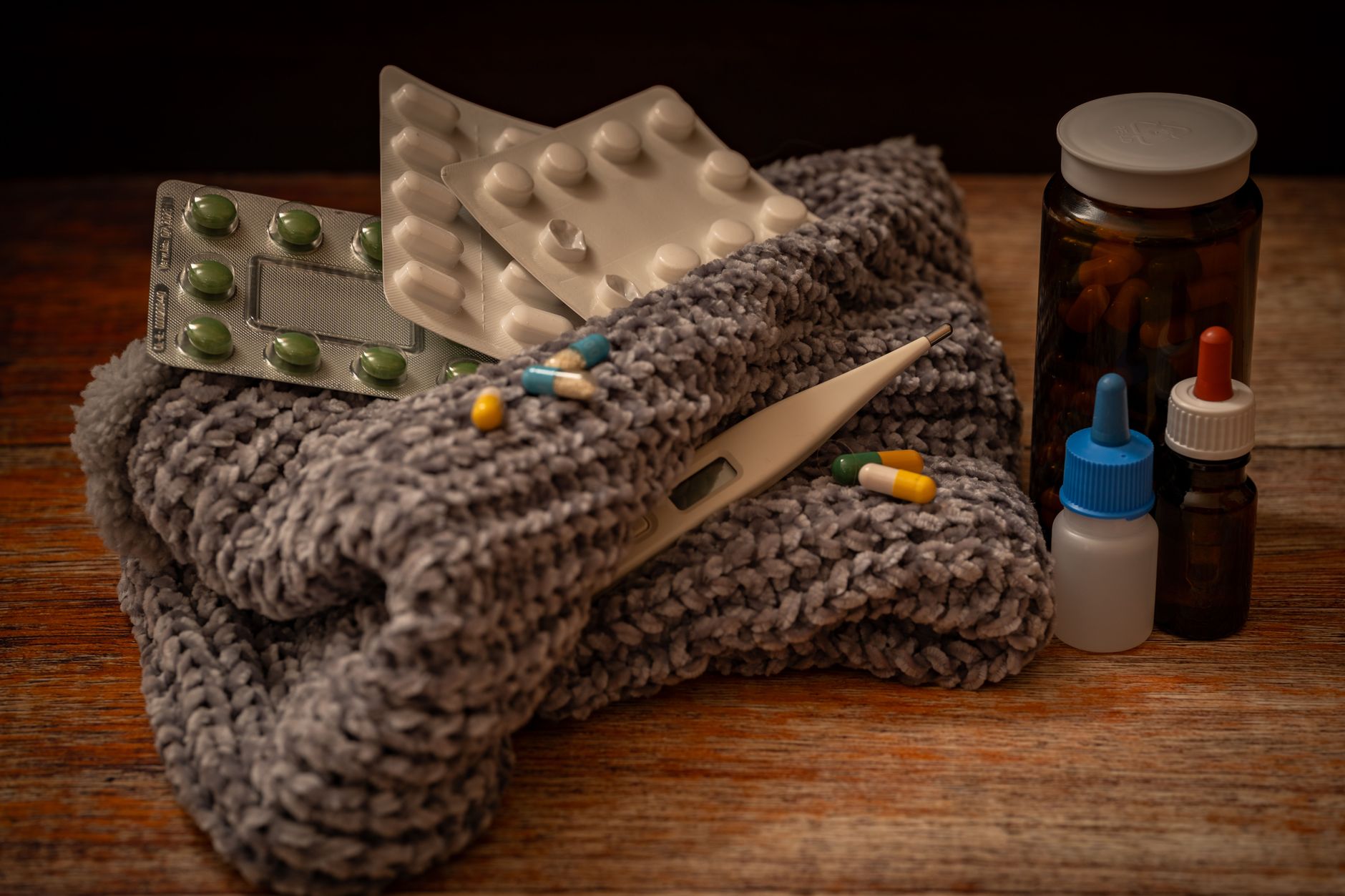 A collection of home remedies for colds and flu including pills, thermometer, and medicine bottles.