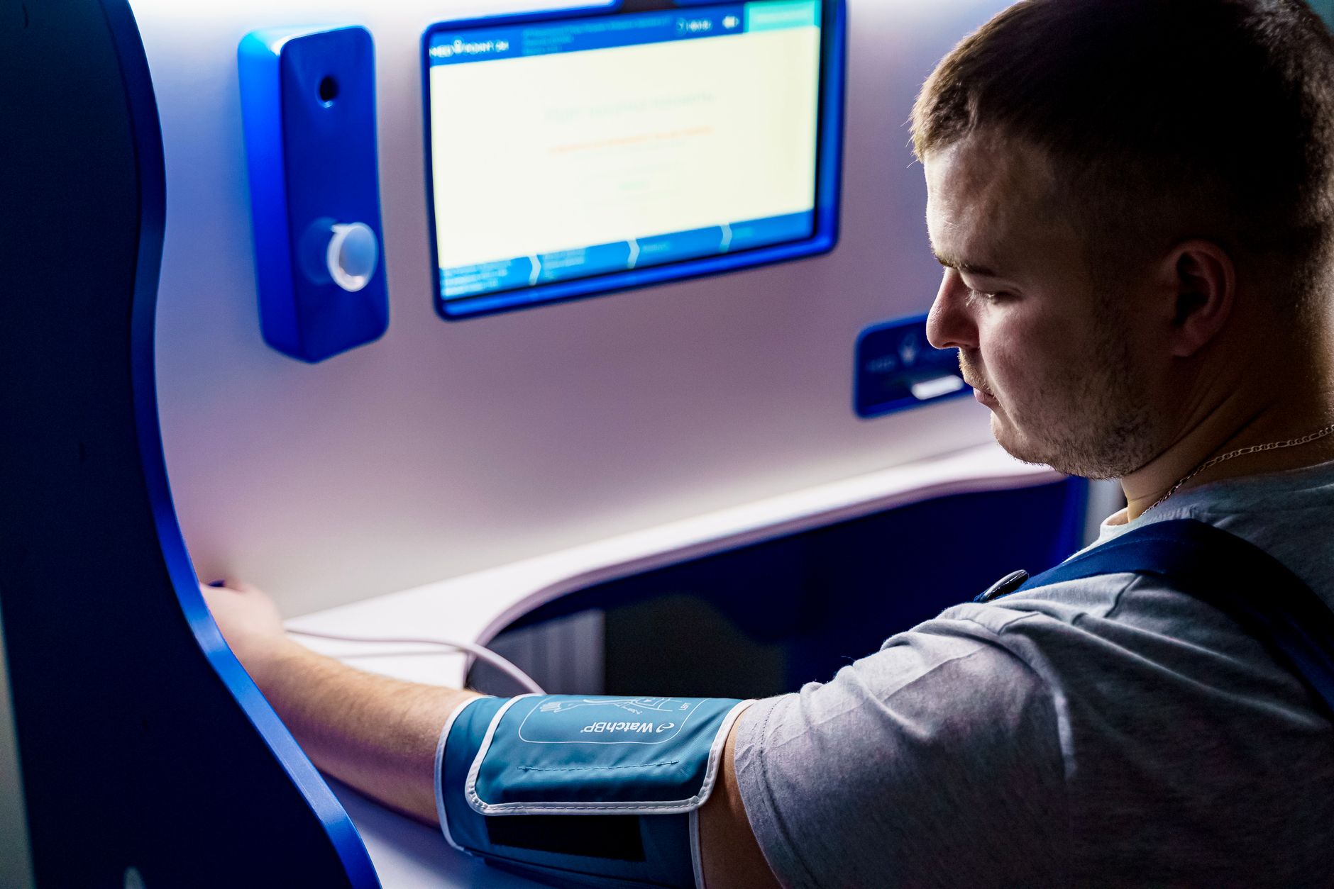 Adult measuring blood pressure with a modern digital monitor indoors.
