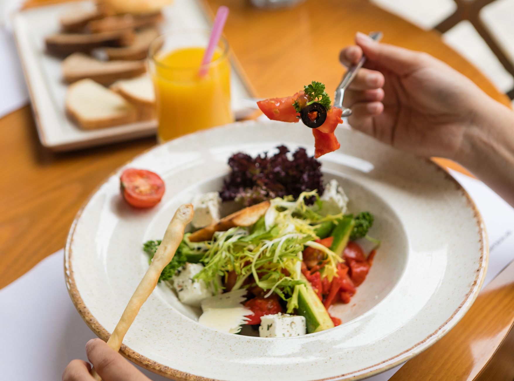 A fresh Greek salad with feta cheese and vegetables on a sunny day.